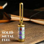Gold metal fruit reel spinner standing upright on a desk beside books.