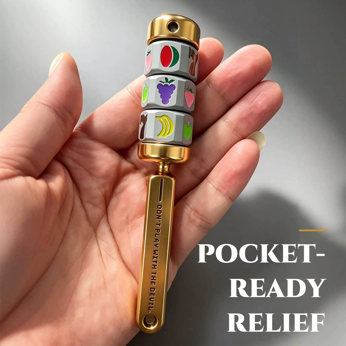 Gold magnetic fruit reel spinner resting in a hand to show its pocket-ready size.