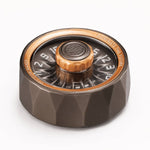 Bronze D20 roulette spinner with numbered wheel and faceted metal base on white.