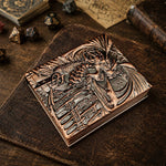 Closed copper dice codex with raised fantasy dragon artwork on the metal cover.