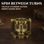 Closed antique gold reloadable dice cylinder standing upright on a leather tabletop.