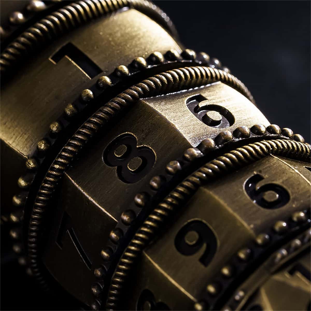 Macro view of antique bronze numbered spinner rings with beaded metal borders.