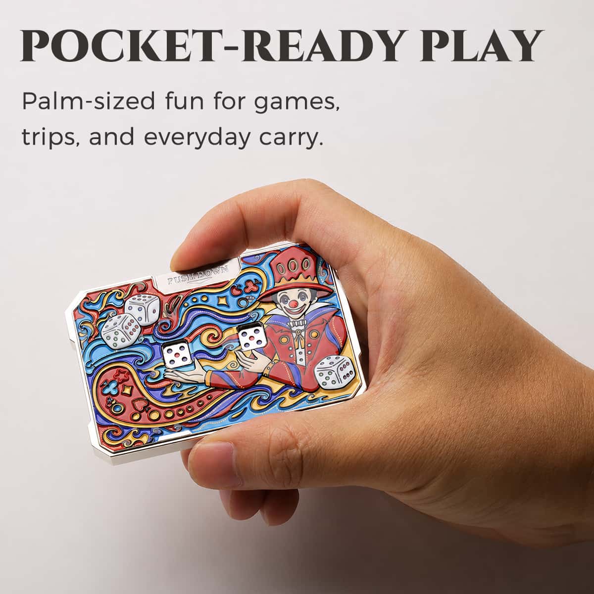 Hand holding a colorful joker mechanical dice card to show its pocket-ready size.