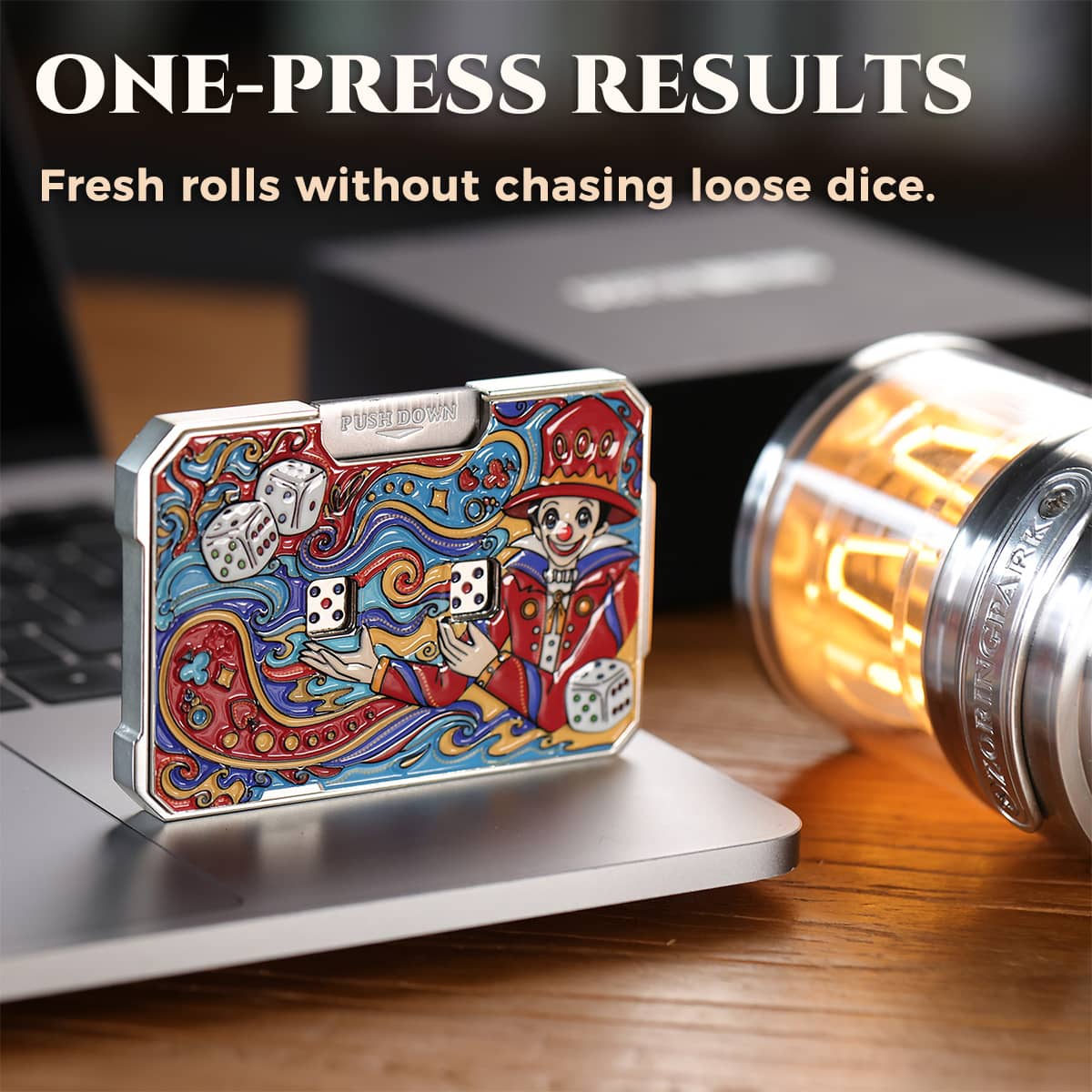 Joker mechanical dice card beside a laptop with the push-down lever visible.