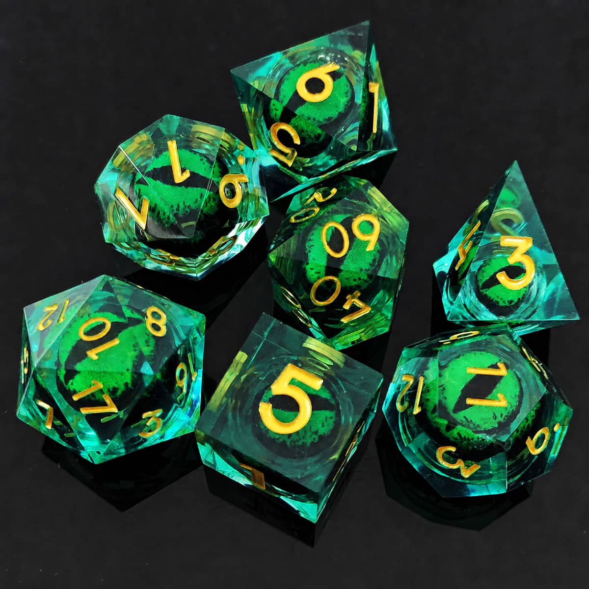 Green moving dragon eye polyhedral dice set with gold numbers on a black background.
