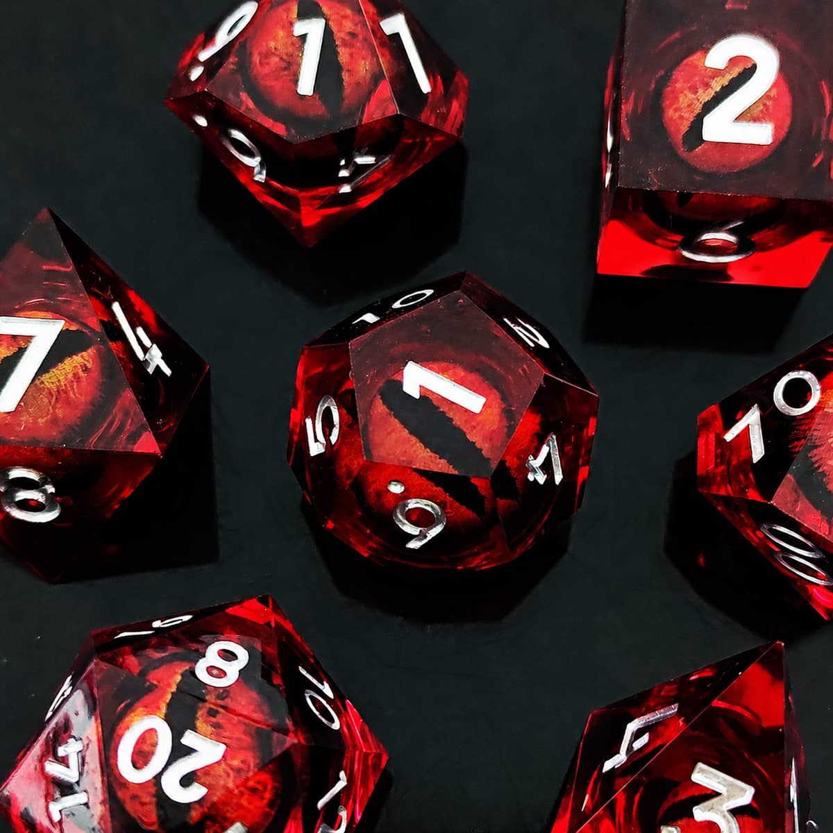 Red moving dragon eye polyhedral dice set with silver numbers on a black background.