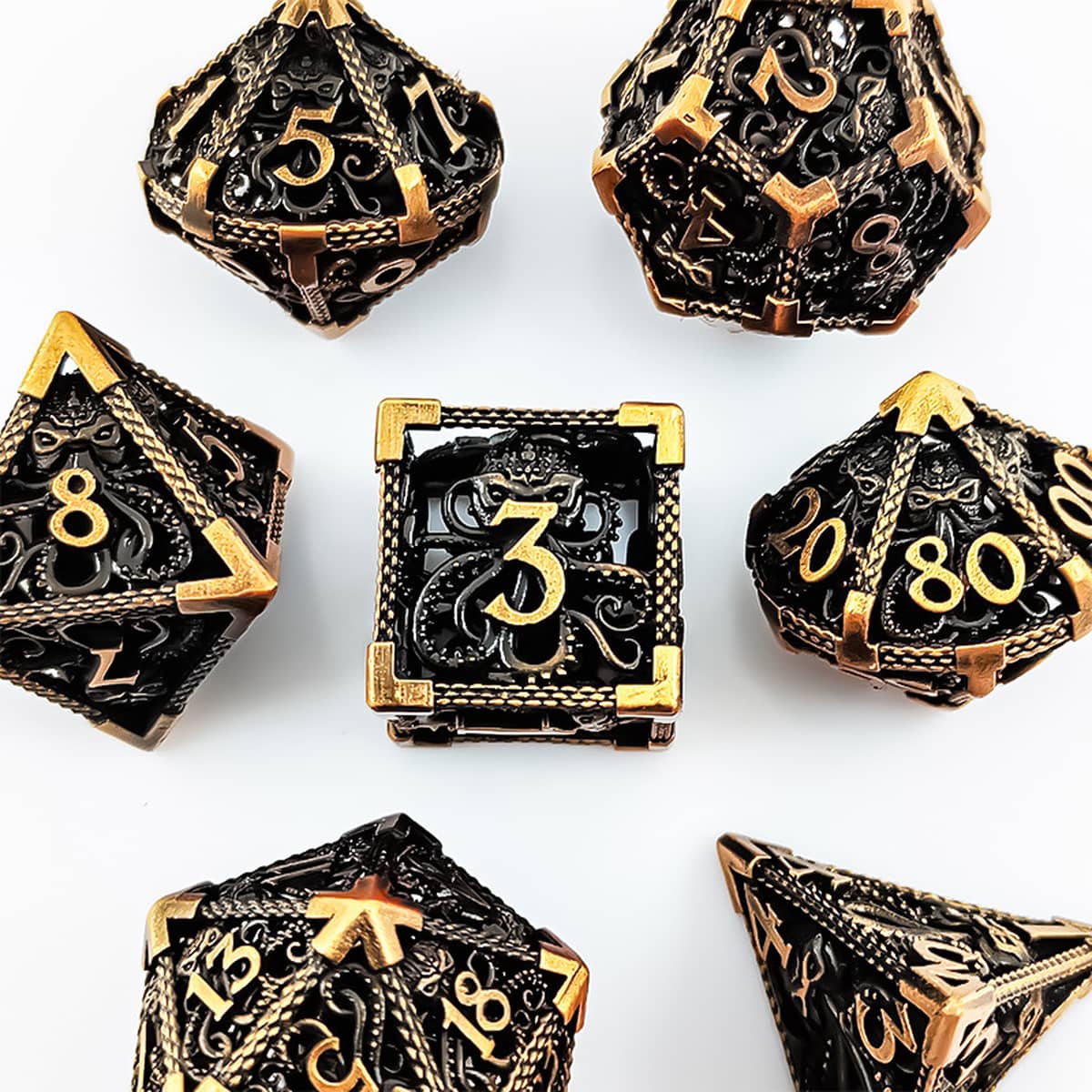Top view of the antique gold seven-piece hollow metal RPG dice set with tentacle designs.