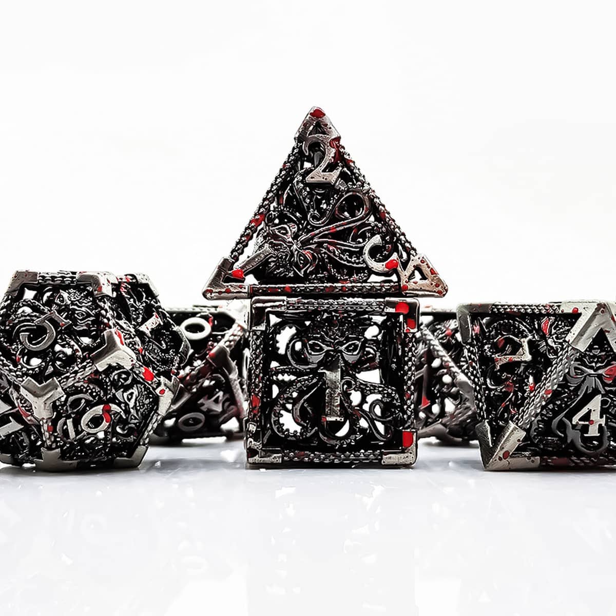 Silver Abyssal hollow metal RPG dice set with red accents and gothic tentacle openwork.